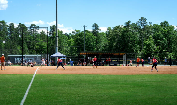 Thumbnail of http://softball%20game%20with%20green%20grass%20outfields%20and%20dirt%20on%20infields.%20Dugouts%20and%20backstop%20in%20background.