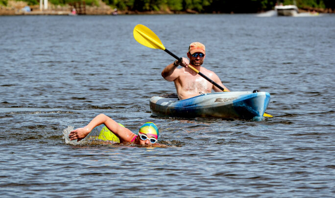 Thumbnail of http://James%20River%20activity%20around%20Robious%20Landing%20in%20Chesterfield,%20Virginia.%20Woman%20swims%20in%20water%20with%20swim%20cap%20while%20kayaker%20follows.